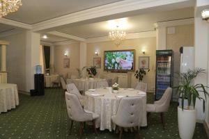 a banquet room with tables and chairs and a tv at BEK PLUS HOTEL in Takchilik