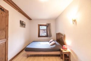 ein kleines Schlafzimmer mit einem Bett und einem Fenster in der Unterkunft Les Fermes de Samoëns in Samoëns + 21 Fotos