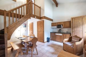 eine Küche mit einer Holztreppe sowie einem Tisch und Stühlen in der Unterkunft Les Fermes de Samoëns in Samoëns