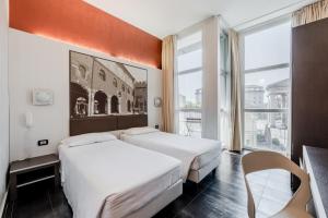a hotel room with two beds and a window at Hotel Milano Navigli in Milan
