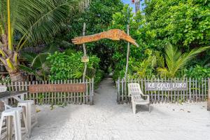 een hek met stoelen en een parasol op het strand bij Victory Seaside Home in Bantayan
