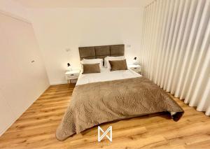 a bedroom with a large bed and wooden floors at MyStay - Encosta da Barragem in Fafe +29 photos