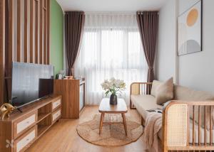 a living room with a couch and a tv at Nature Hotel - Le Hong Phong in Da Lat +69 photos