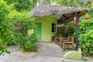 a small green house with a table and chairs at Victory Seaside Home in Bantayan Island