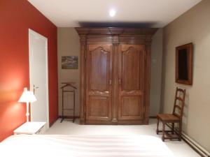 1 dormitorio con armario de madera y cama en Maison Chantraine, en Ramillies