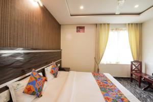 a hotel room with a bed and a window at FabHotel Prime Suloka Towers - 500m from View point, Kaveri River in Kushālnagar +20 photos