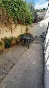 a patio with a table and chairs next to a building at Well Cottage in Beckington
