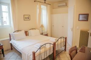 a bedroom with a bed and a window at Archontiko Eleni Hotel in Andros