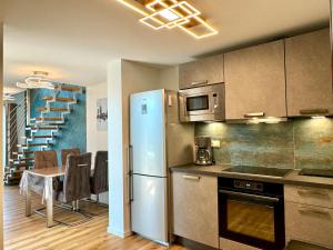 a kitchen with a refrigerator and a table with chairs at Aparthotel Kottenforst in Bonn