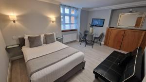a hotel room with a large bed and a table at Aspen Hotel in London