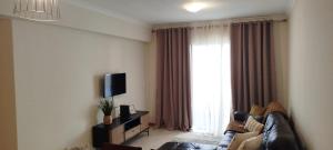 Una sala de estar con un sofá y una ventana grande. en Apartamento Quitéria - Funchal, en Funchal 9 fotos más