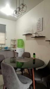 a kitchen with a table and chairs in a room at MIC'S GuEST HOUSE in Maslog