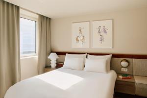 une chambre avec un lit blanc et une fenêtre dans l'établissement Revier, à Oslo