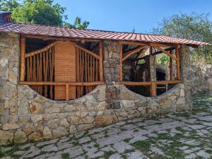 a stone building with a wooden fence on it at Paradise Guest House in Tsaghkadzor