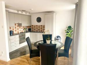 a kitchen with a table and chairs in a room at Waterfoot Escape in Newcastle