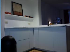 cocina con armarios blancos y encimera en Signature Designers Appartment, en Bruselas