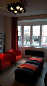 a living room with two ottomans and a couch and windows at Signature Designers Appartment in Brussels