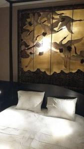 a bedroom with a bed with a painting on the wall at Signature Designers Appartment in Brussels