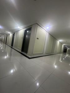 a hallway of a building with white floors and doors at itten plaza blue in Salalah