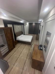 a small bedroom with a bed and a wooden floor at itten plaza blue in Salalah