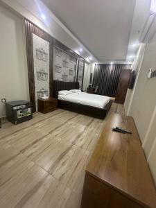 a bedroom with a bed and a wooden floor at itten plaza blue in Salalah