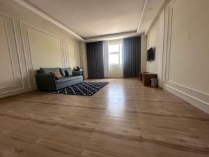 an empty living room with a couch and a television at itten plaza blue in Salalah