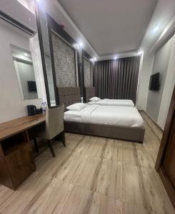 a bedroom with a bed and a desk and a desk at itten plaza blue in Salalah