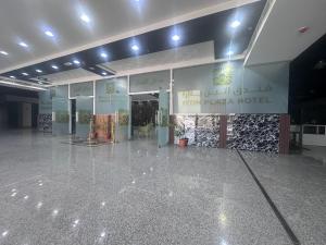 a lobby of a hotel with a large concrete floor at itten plaza blue in Salalah