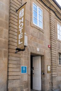 una señal en el lateral de un edificio con una puerta en Hotel A Tafona do Peregrino, en Santiago de Compostela