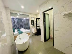 un bagno con vasca e una camera da letto di Khách sạn Chè yến Nha Trang a Nha Trang