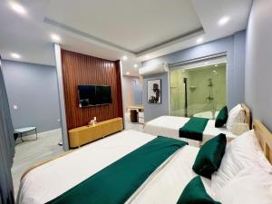 una camera d'albergo con due letti e una televisione di Khách sạn Chè yến Nha Trang a Nha Trang