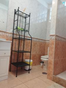 ein Badezimmer mit einem WC und einem schwarzen Regal in der Unterkunft Casa Padrón! Paraíso junto al MAR in Puerto de Santiago + 13 Fotos