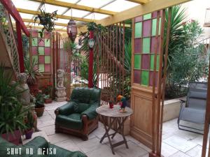 a patio with a chair and a table and some plants at Le couvent des Capucines - La Suite Comedia del Arte in Saint-Vallier +6 photos