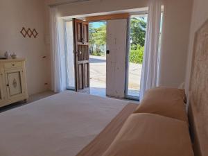 een slaapkamer met een bed en een open deur bij Holiday Home Trullo Antico in Ostuni