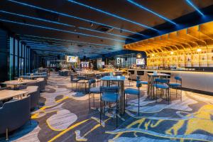 a restaurant with tables and chairs and a bar at Betworld Casino & Hotel in Krong Poi Pet