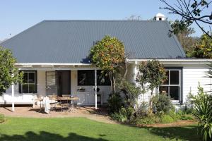 a white house with a table in a yard at Kumbuk House in Franschhoek +11 photos
