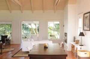 a living room with a white couch and a table at Kumbuk House in Franschhoek