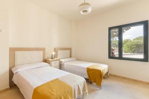 a bedroom with two beds and a window at El Oasis Martinica 2 Bajo B in Fuente Alamo +15 photos