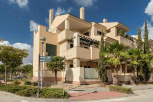 a building with palm trees in front of it at El Oasis Martinica 2 Bajo B in Fuente Alamo