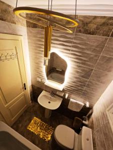 a bathroom with a sink and a toilet and a light at Garden view apartment in Madinaty +32 photos