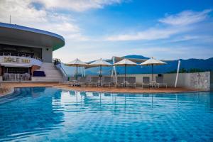 a swimming pool with tables and umbrellas on a building at Sole Mio Boutique Hotel and Wellness - Adults Only in Bang Tao Beach