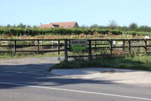 a sign on a fence next to a field of flowers at The Lodge in Storrington