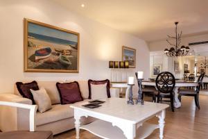 a living room with a couch and a table at Princess Resort, Santikos Collection in Agia Paraskevi