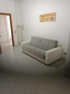 a living room with a couch sitting on a tile floor at SUITE - 2 Camere da Letto - Fiumicino Aeroporto e Fiera in Fiumicino
