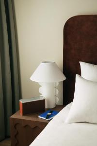 a lamp on a night stand next to a bed at Revier in Oslo