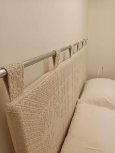 un letto bianco con una sponda di metallo accanto di Loft Delitala 1 ad Alghero