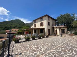 a building on a stone courtyard with a house at Casa Vacanze Vecchio Frantoio Residenza Moraiolo in Spoleto