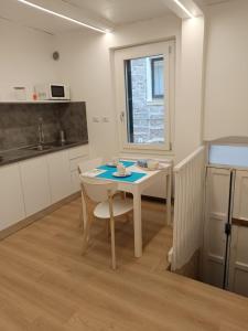 una cucina con un tavolo bianco e un tavolo e sedie di Loft Delitala 1 ad Alghero Altre 16 foto