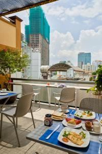 a table with two plates of food on a balcony at Chez Mimosa Petite - Free Laundry in Ho Chi Minh City