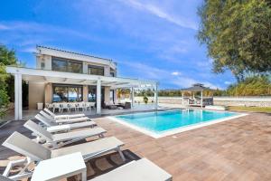 a house with a swimming pool and chairs at Kiotari Dream beachfront villa in Gennadi